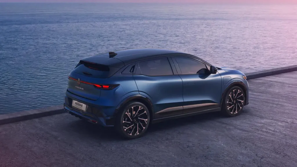 Renault électrique bleue de profil, stationnée près du littoral.