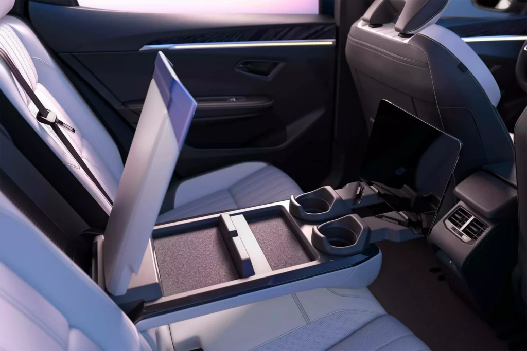 Console centrale du Renault Scénic E‑Tech avec rangements, porte-gobelets et éclairage d’ambiance.
